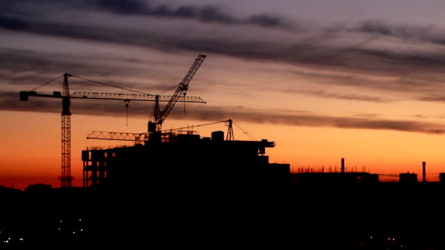 Construction-of-high-rise-building-against-on-the-background-of-sunrise,-time-lapse