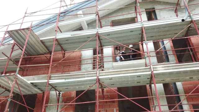 Engineer-And-Customers-Buying-New-Apartment-In-Construction-Site