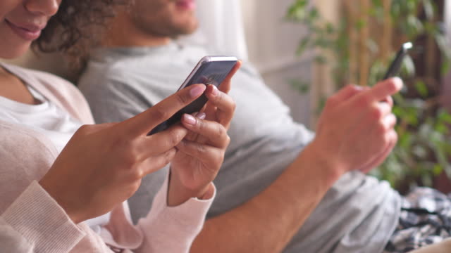 Paar,-die-Benutzung-von-Mobiltelefonen-im-Bett-zu-Hause