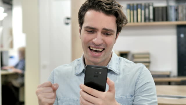 Creative-Man-Excited-for-Success-while-Using-Smartphone