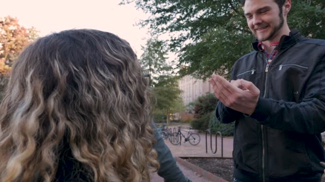 Männliche-College-Student-mit-der-Hand-zu-erklären,-wie-man-ein-mobiles-Gerät