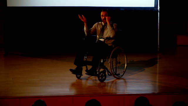 Maduro-hombre-de-negocios-discapacitados-con-discapacidad-hablando-en-seminario-de-negocios-en-auditorio-4k