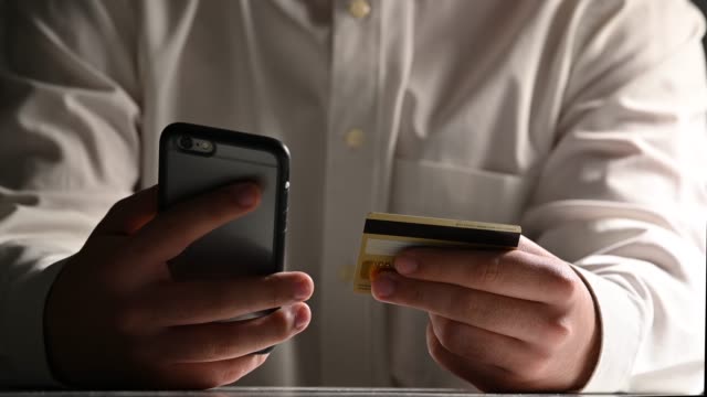 Hombre-banca-en-línea-utilizando-compras-de-teléfonos-inteligentes-en-línea-con-tarjeta-de-crédito-en-el-lugar-de-trabajo