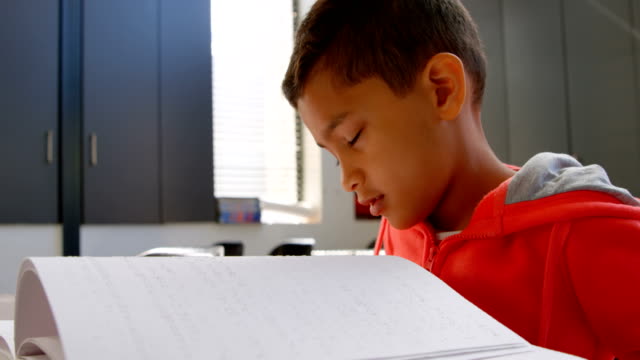 Seitenansicht-blinder-asiatischer-Schuljungen,-die-ein-Braille-Buch-im-Klassenzimmer-der-Schule-4k-lesen