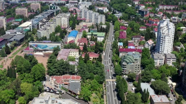 Aerial-video-shooting.-Sochi-city-center-from-a-height.-Panorama-shooting.-Many-houses,-hotels,-hostels-in-the-city-center.-Urban-infrastructure.-Clear-blue-sky.-Metropolis-against-the-mountains.