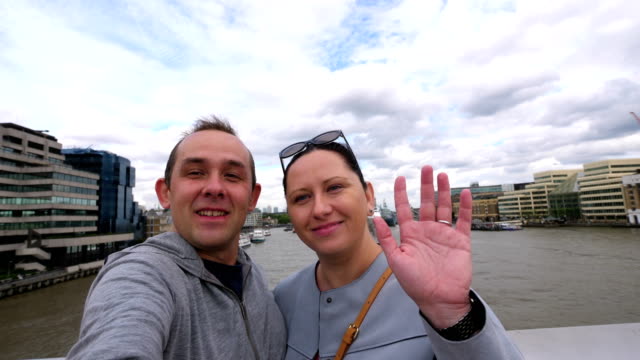 Couple-taking-selfie-with-a-view-of-Thames-river-and-the-Shard-skyscraper-in-London-in-4k-slow-motion-60fps