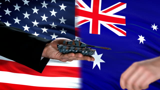 USA-and-Australia-officials-exchanging-tank-money,-flag-background,-weapon-trade