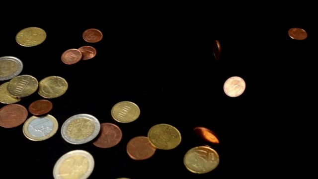 Coins-fall-on-a-black-background.-Slow-motion.
