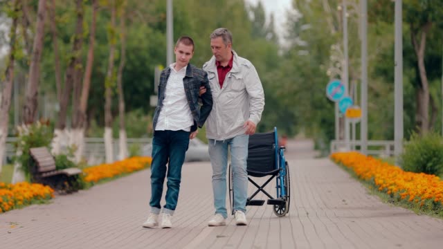 Guy-mit-Behinderung-kommt-mit-der-Unterstützung-seines-Vaters.