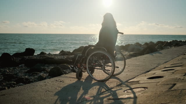Behinderte-Frau-im-Rollstuhl-starrt-aufs-Meer