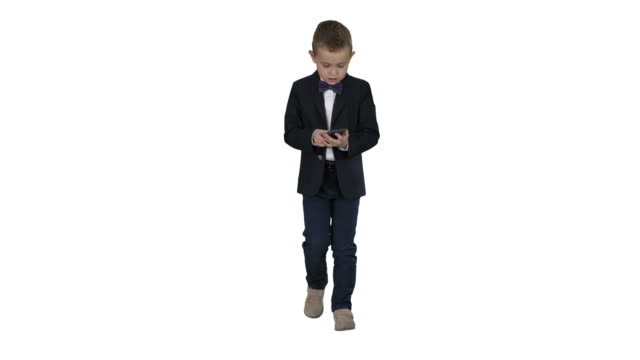 Kleiner-Junge-in-Kostüm-zu-Fuß-und-mit-Smartphone-auf-weißem-Hintergrund