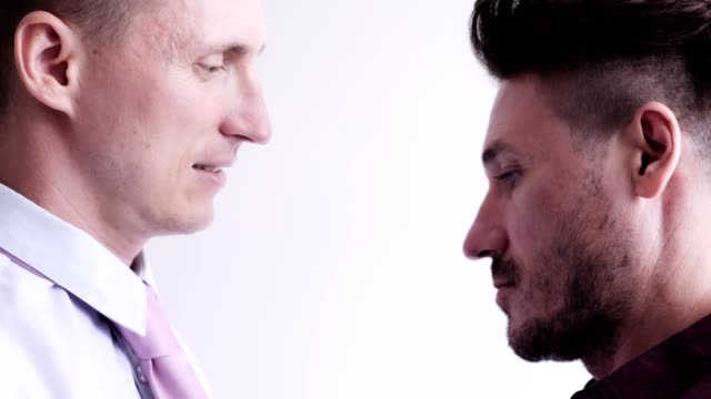 Hombre-gay-ayudar-a-su-pareja-a-poner-corbata-para-la-entrevista-de-trabajo.-Hablando-y-besándose.