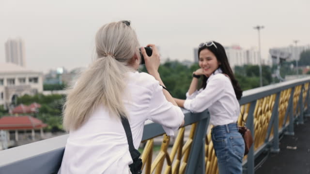 Asiatische-lesbische-Paare-genießen-Reisen-mit-Filmkamera-ein-Foto.-Zwei-schöne-junge-Frauen,-die-Spaß-in-der-Ferienzeit-haben.