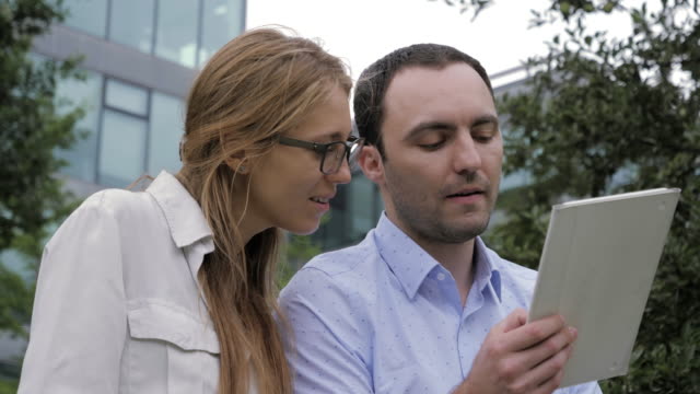 Geschäftsleute-treffen-sich-draußen-mit-elektronischem-Tablet