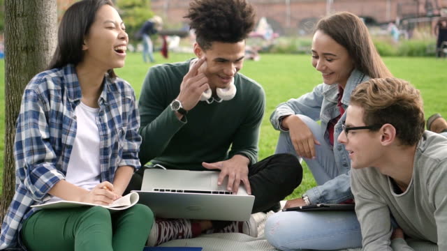 Porträt-von-multiethnischen-Gruppe-von-aufgeregten-erwachsenen-und-glücklichen-amerikanischen-Freunden-hängen-auf-Universitätsraum-kollorating-mit-Laptop