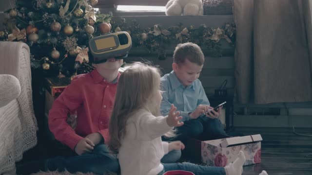 kleine-Jungen-spielen-mit-modernen-Gadgets-und-Mädchen-öffnet-Gegenwart