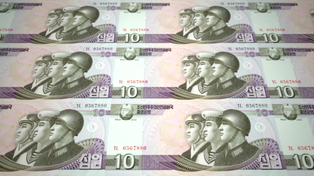 Banknotes-of-ten-wons-of-North-Korea-rolling,-cash-money,-loop