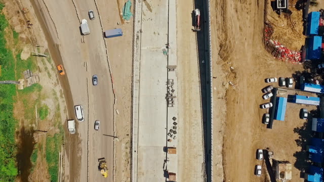 aerial-shot-of-construction-of-highway-in-russian-city,-camera-looking-down-and-moving-along