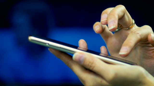 Nahaufnahme-eines-jungen-Mädchens-blättert-Seiten-im-Internet-auf-Smart-Phone-auf-einem-Laptop-Bildschirm-Hintergrund.