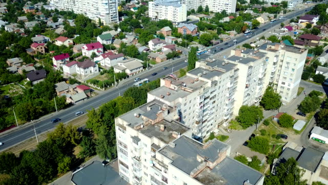 View-from-the-height-to-the-busy-street-of-the-city-with-a-lot-of-different-cars-and-on-the-roof-of-multi-storey-buildings.