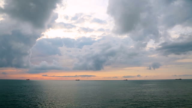 Hora-de-oro-en-la-orilla-del-mar,-barcos-de-carga-en-el-transporte-comercial,-puesta-de-sol