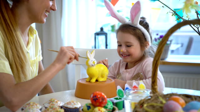 ¡Feliz-Pascua-de-resurrección!-Madre-y-su-hija-pequeña-con-orejas-de-conejo-pintar-conejito-de-Pascua
