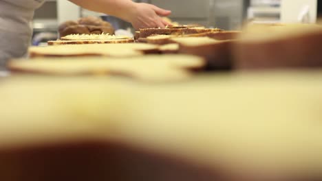 pastry-chef--hands-stuffed-Easter-sweet-bread-cakes-with-custard,-closeup-on-the-worktop-in-confectionery