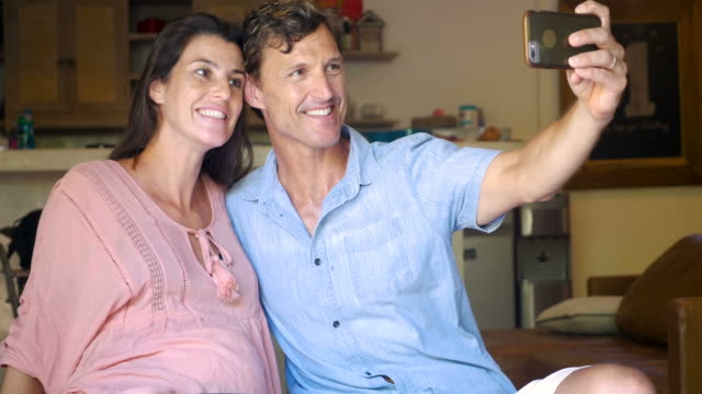 Schwangere-Frau-und-Mann-unter-Selfies-mit-einem-Mobiltelefon-Grimassen