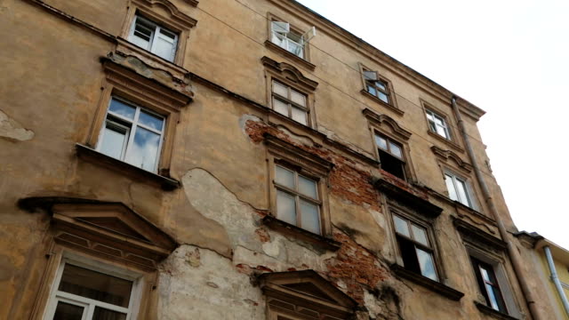 Aged-building-facade-with-broken-windows-in-old-historical-town,-loneliness