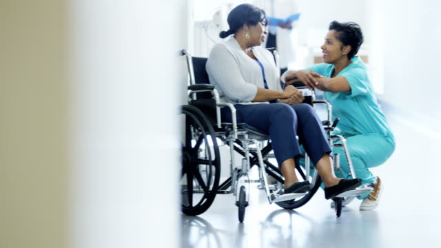 Multi-ethnischen-Team-mit-älteren-Patienten-im-Rollstuhl