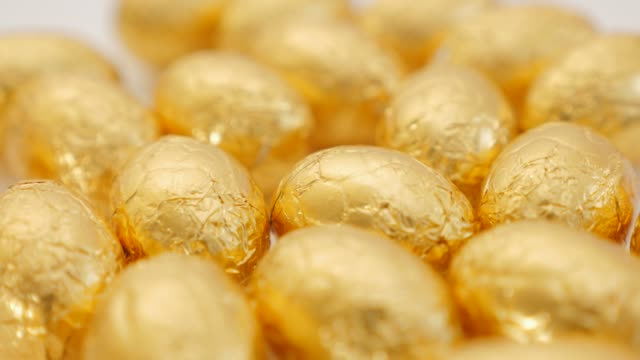 Schokolade-Ostereier-goldenen-auf-weiße-Fläche-langsam-schwenken-4K