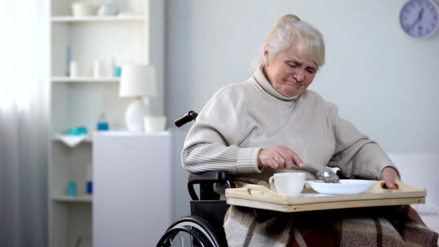 Launische-alte-Dame-im-Rollstuhl-Fragen-Krankenschwester-Einnahme-Weg-unappetitlich-Abendessen