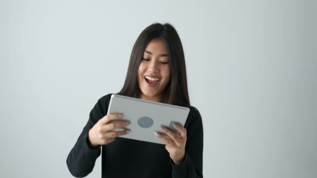 Happy-woman-playing-game-on-digital-tablet