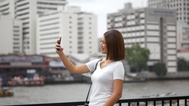Touristische-junge-asiatische-Frau,-die-mit-dem-Smartphone,-das-sich-mit-Freunden-in-den-Sommerferien-in-den-sozialen-Medien-verbindet,-videochat-macht.