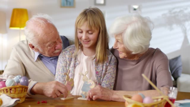 Großeltern-lachen-und-schmundern-beim-Spielen-mit-Enkelin