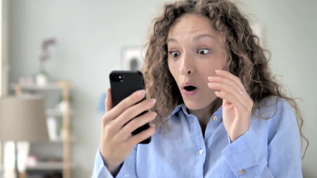 Wow,-Excited-Woman-in-Surprise-while-Using-Smartphone