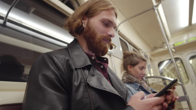 Pasajeros-que-usan-teléfonos-en-el-vagón-de-metro