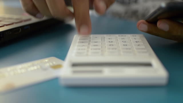 Hands-of-a-man-calculating-expenses-from-credit-card.