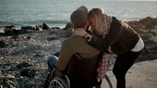 Hombre-discapacitado-con-novia-junto-al-mar