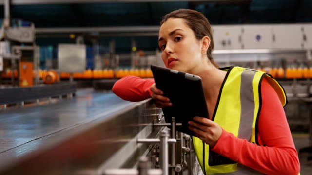 Weibliche-Supervisorin-mit-digitalem-Tablet-in-der-Nähe-der-Produktionslinie