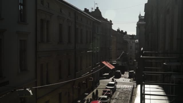 Old-European-street-on-sunset-people-car-traffic-tram-crosses