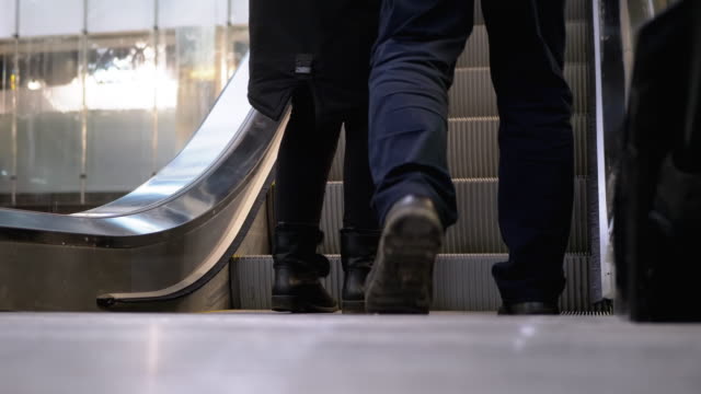 Legs-of-People-Moving-on-a-Escalator-Lift-in-the-Mall.-Shopper-es-Feet-auf-Rolltreppe-im-Einkaufszentrum