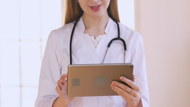 Vista-de-cerca-de-la-mujer-médico-utilizar-pantalla-táctil-tableta-digital