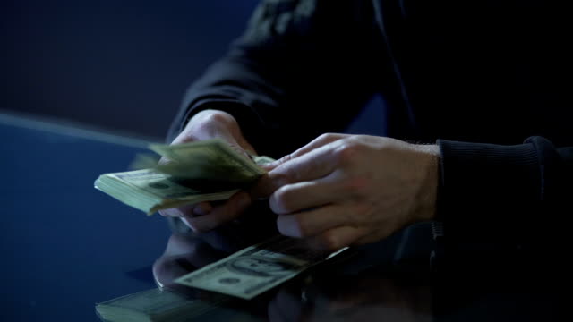 Hände-von-Vertragsmörder-oder-Bankräuber-zählen-Geld-für-die-Begehung-von-Verbrechen-bezahlt
