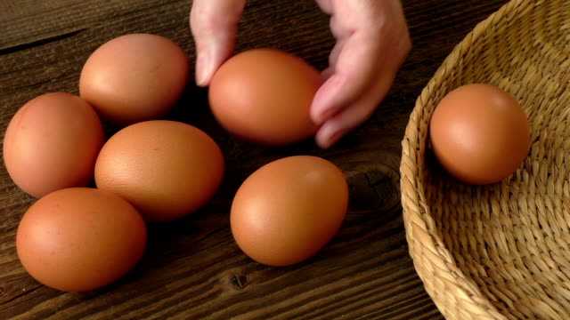 Marrón-de-huevo-en-una-cesta-en-la-mesa-de-madera,-huevo-de-pollo