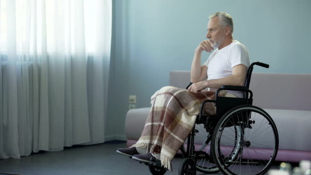 Elderly-man-in-wheelchair-deciding-to-move-forward,-strong-will-for-recovery