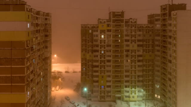 A-snowstorm-in-the-city.-View-from-the-window-to-the-courtyard-at-night.-top-down