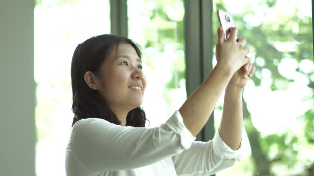 Mujer-asiática-toma-selfie.