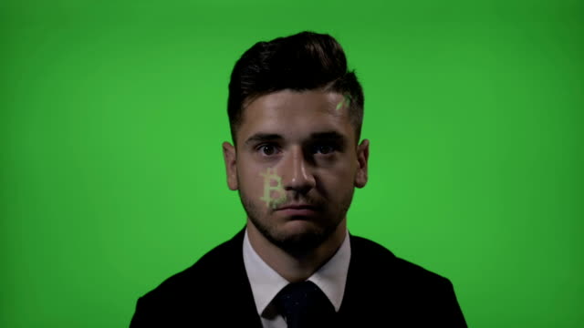 Bitcoin-crypto-currency-symbol-projected-on-the-face-of-a-smiling-excited-businessman-investor-with-a-green-screen-background