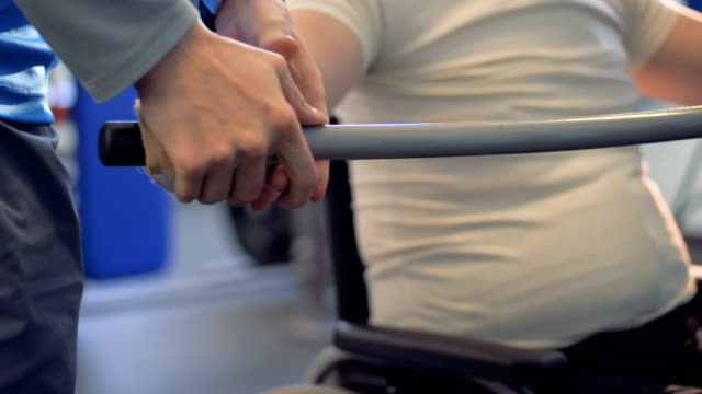 Una-persona-está-ayudando-a-ajustar-una-barra-en-las-manos-de-un-hombre-discapacitado